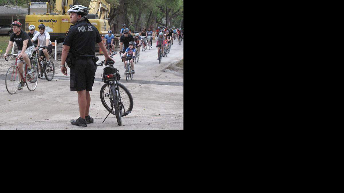 
A Fort Worth policeman watches an intersection as riders on Mayor Betsy Price's Rolling Town Hall bike ride make their way through west Fort Worth, Texas on Wednesday, April 2, 2014. 
