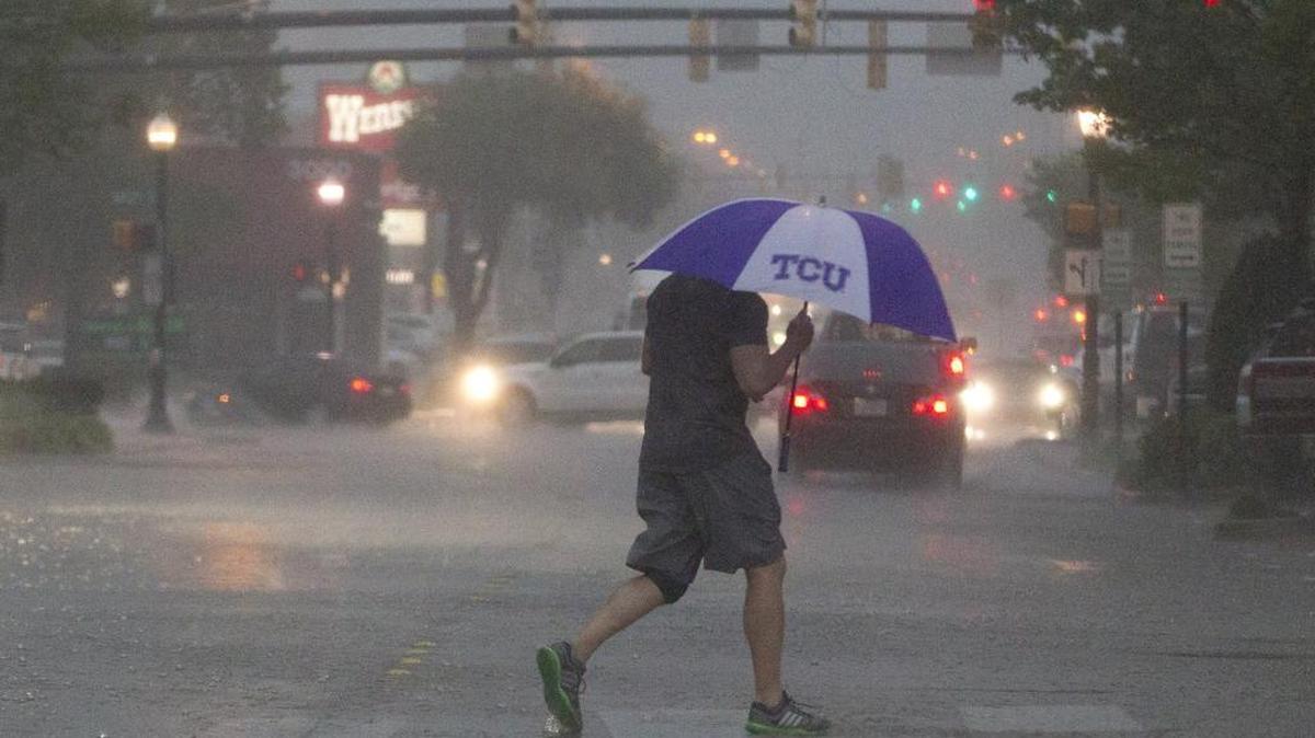 Rain hit north Texas on March 30, which caused pedestrians crossing West 7th street to run for cover.
