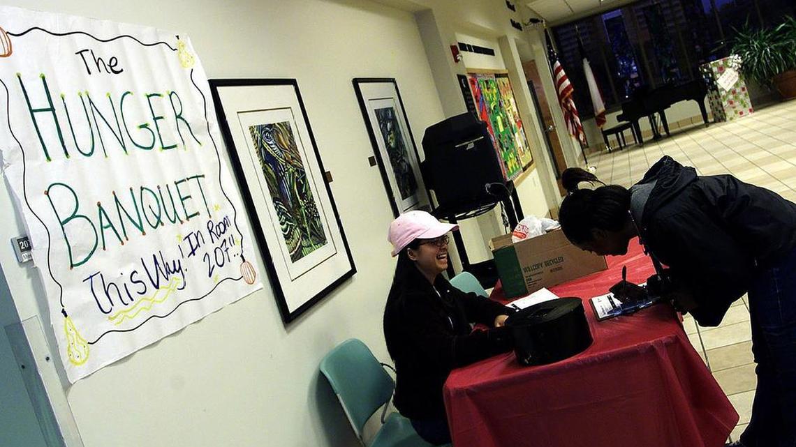 FILE: Poverty has long been a major issue in North Texas. Lashandea Black signs in to the Hunger Banquet held at Texas Woman's University, as Ha Tran looks on. The assembly brought to light the world hunger and poverty situation. 11-17-04 Special to the Star Telegram William Miskiewicz --NE Metro--
