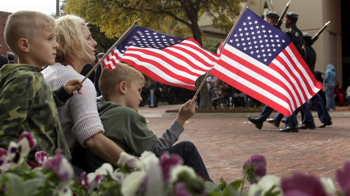 Shelley Dorsey and her sons Barrett, left, and Greyson watch the Tarrant County Veterans Day Parade in downtown Fort Worth on Saturday.