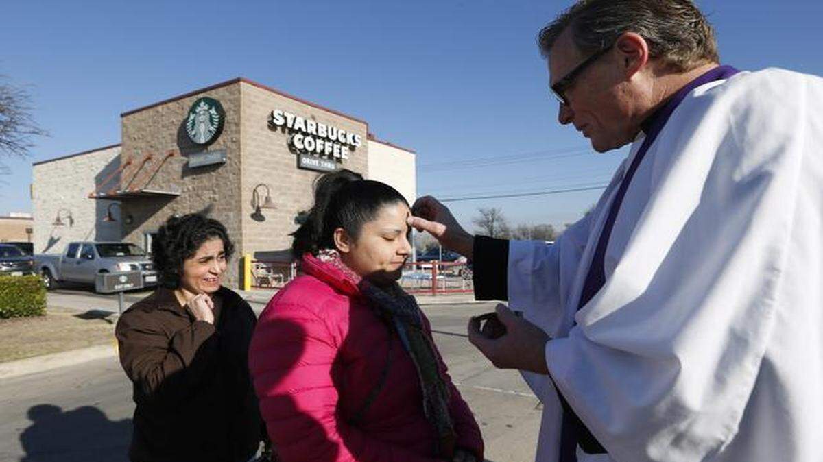 
The Rev. Bill Stanford of St. Christopher Episcopal Church gives Ash Wednesday blessings to Maria Ortiz, center, and her sister Olga Ortiz near a Starbucks in southwest Fort Worth.
