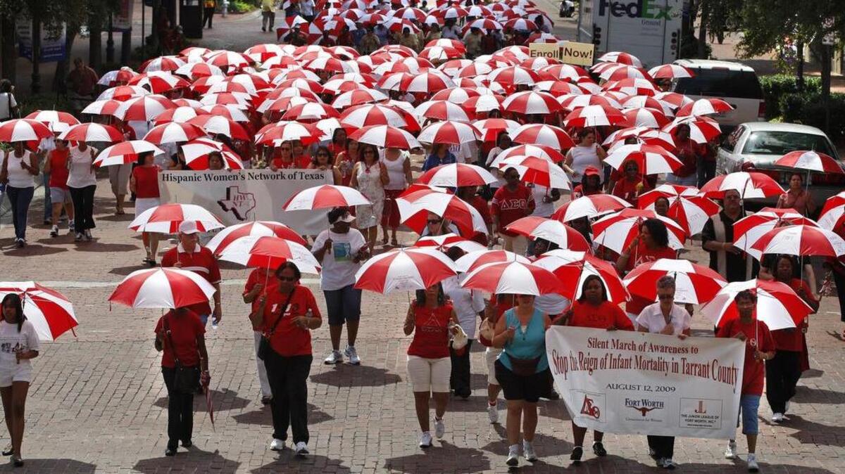 Hundreds carried red and white umbrellas up Main Street in downtown Fort Worth in a march against infant mortality on Aug. 12, 2009.