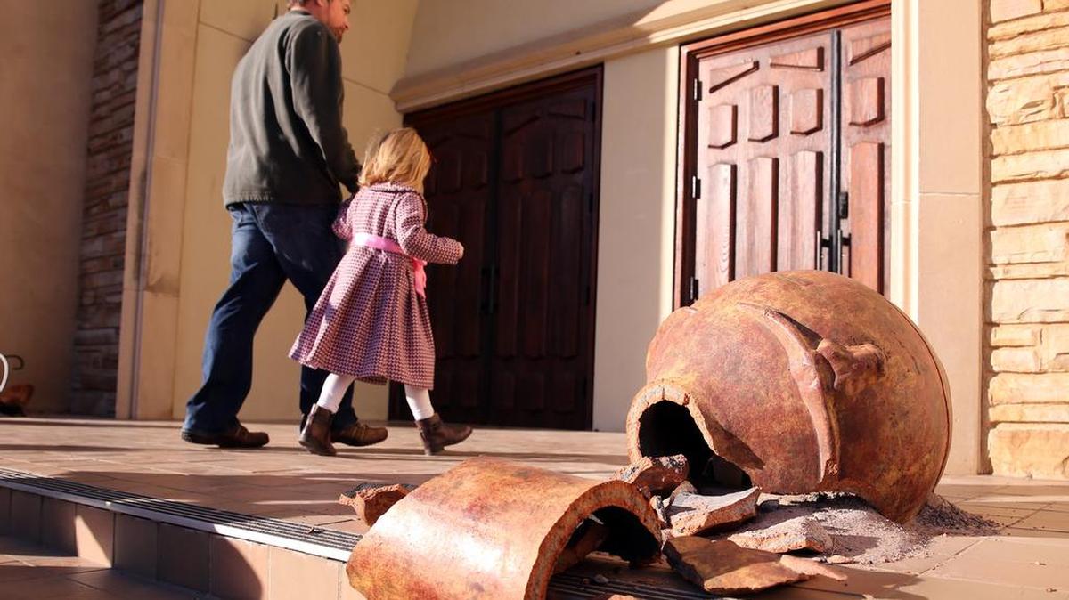 Churchgoers walk past a broken pot and enter St. Stephen Presbyterian Church for a vigil Sunday afternoon.