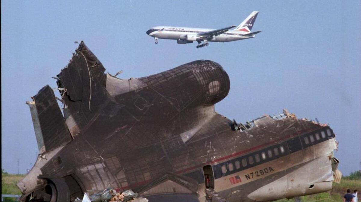 A Delta plane flies by the wreckage of Delta Flight 191 the day after the Aug. 2, 1985, crash.