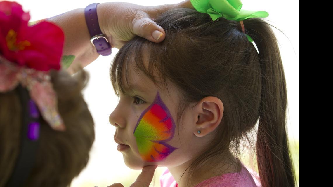
Diane Williams paints a butterfly for Lily Velasquez, 4, of Saginaw on the first day of Mayfest on Thursday. This year marks the 20th anniversary of the Mayfest hailstorm.

