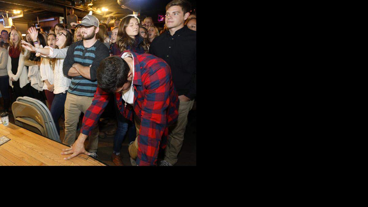 
TCU football players Colten Christensen (wearing hat) and Chase Distasio (foreground with head bowed) react after learning that TCU will not be one of the four teams in the College Football Playoff. Students gathered at a watch party at the Aardvark near the TCU campus on Sunday, Dec. 7, 2014.
