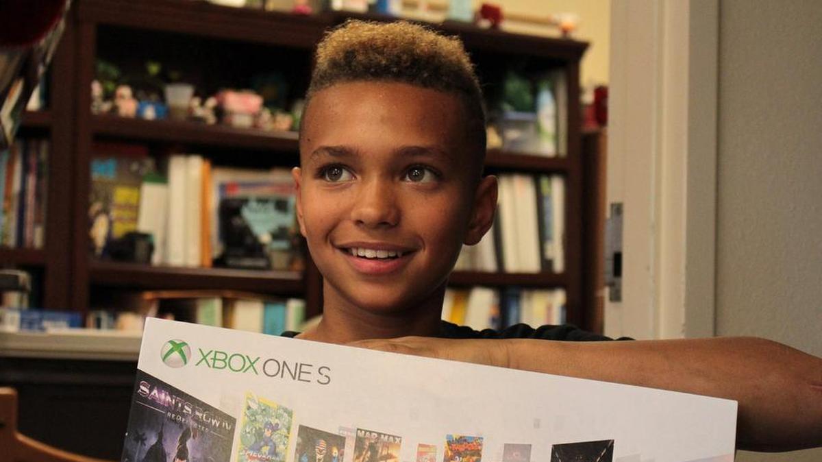 Brayden Gardner, 12, whose mother was tragically killed last mother as he and his sister slept nearby, shows off presents he received during a special Winter Wonderland party at Daggett Middle School in Fort Worth.