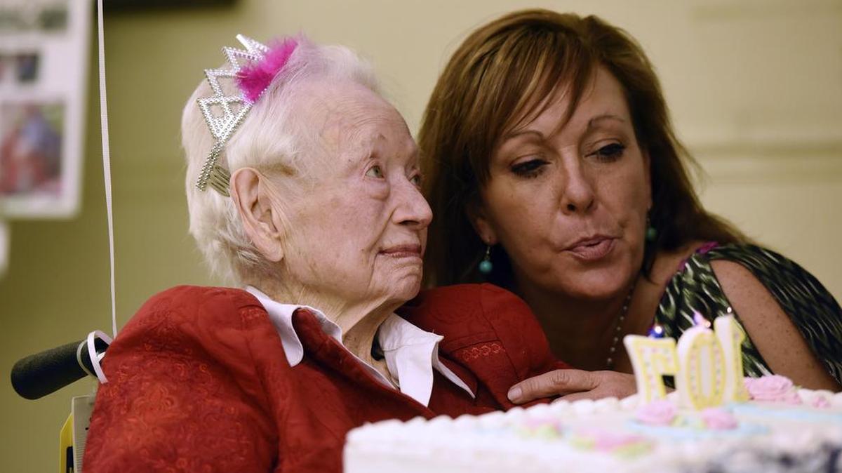 Activity director Shana Kennedy helps Janette Gillespie blow out her birthday cake candles as she celebrates her 107th birthday Monday at Oakbrook Health Care Center in Whitehouse. Gillespie graduated from TCU in 1932.