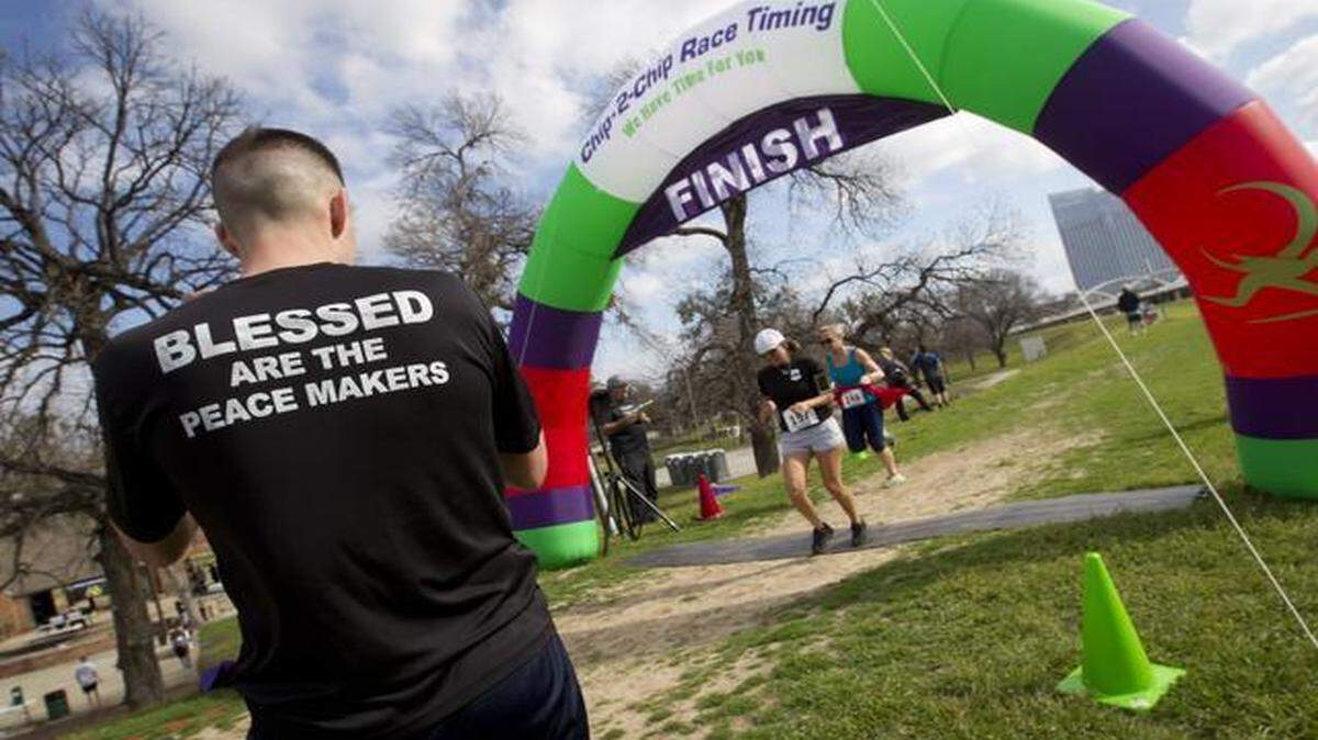 
A Fort Worth police officer, left, waits for a fellow officer, center, to cross the finish line at the inaugural Officers Down 5K Run/Walk on Saturday in Fort Worth. The event was a fundraiser for the Fort Worth Police and Firefighters Memorial. 

