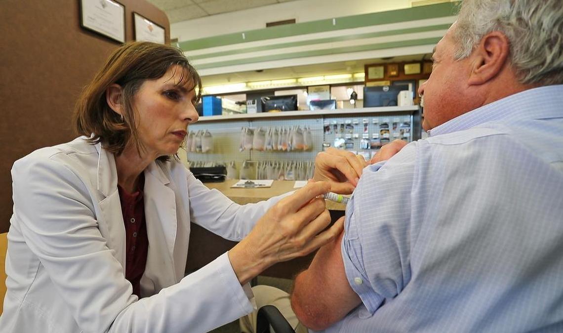Kenna Starnes, part time pharmacist at Perrone Pharmacy, administers a flu shot to Jerry Leverett, Perrone Pharmacist. If you haven’t already received a flu shot, officials are advising individuals to do so.