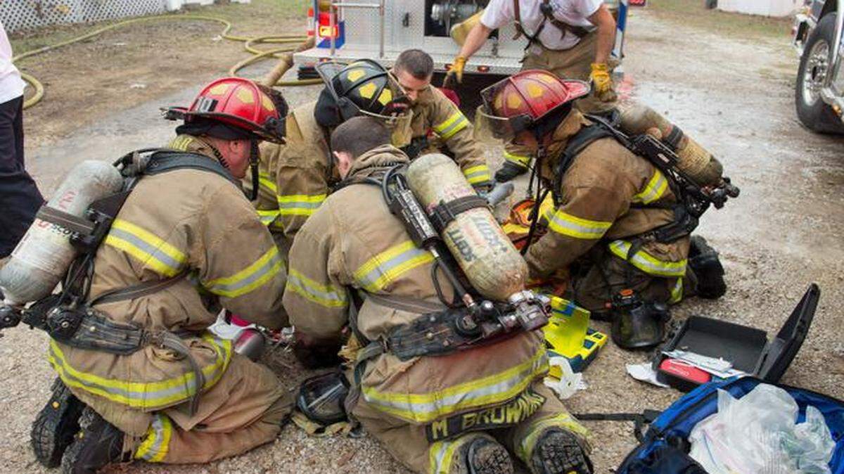 
Fort Worth firefighters perform emergency medical services on a man found in his burning mobile home Sunday. 
