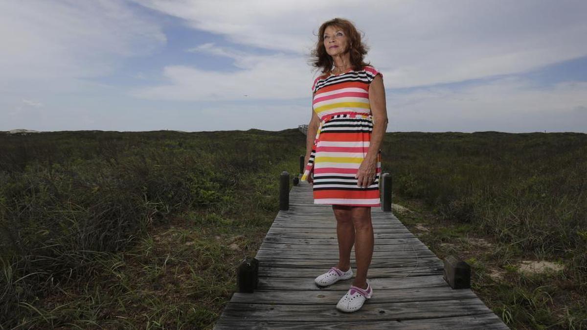 Sonia Cacy poses for a photo on a boardwalk near her home, Tuesday, June 24, 2014, in Port Aransas, Texas. Cacy, who is now on parole, has waited decades for for her murder conviction to be overturned. She has fought more than 20 years to clear her 1993 conviction in the death-by-fire of her uncle, Bill Richardson in Fort Stockton, Texas. (AP Photo/Eric Gay)