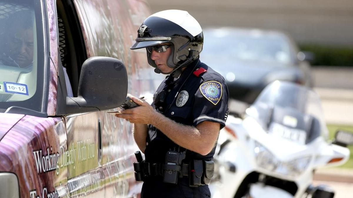 File photo of Colleyville police officer C. Tinsman writing a ticket for seat belt violation in Colleyville on May 22, 2012.