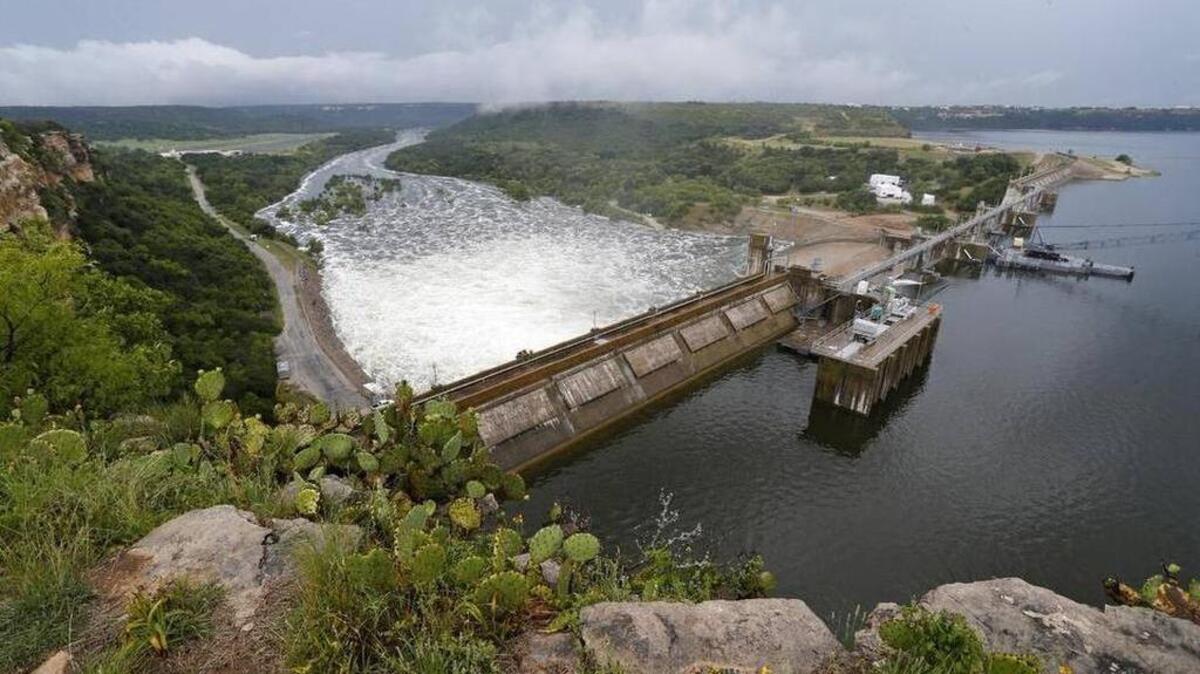 Heavy rains have swollen Possum Kingdom Lake, with water pouring over Morris Sheppard Dam (seen from the Brazos River Authority offices) in Graford on Tuesday.