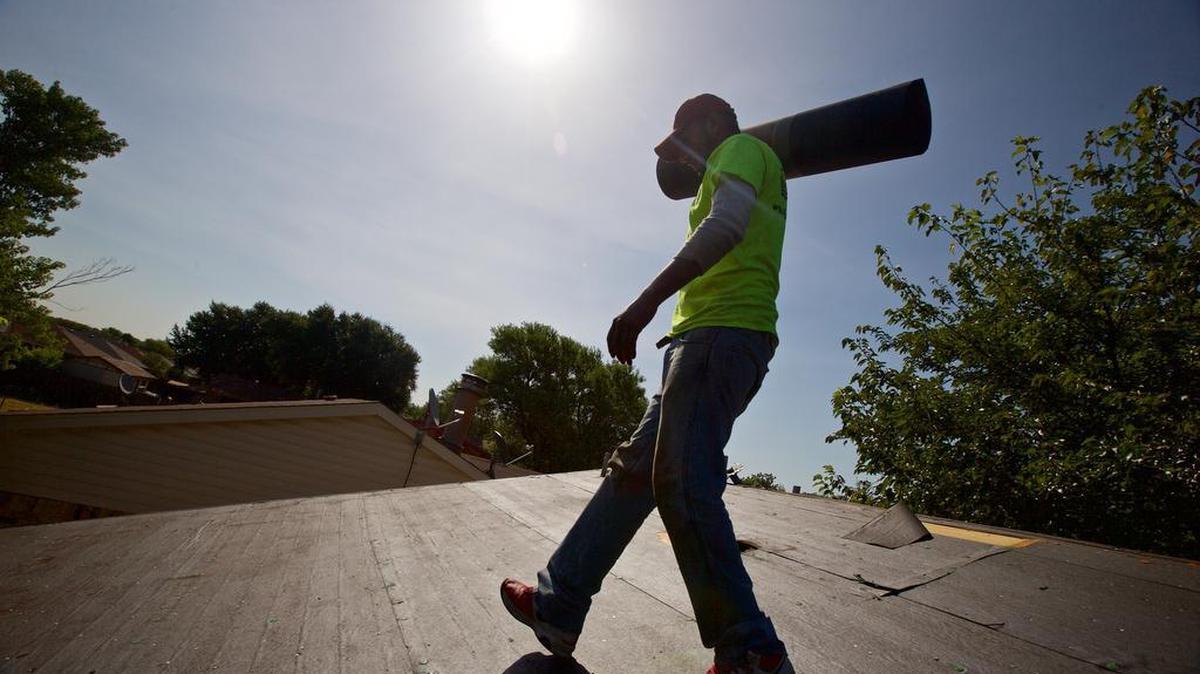 
Roofer Jose Suarez, with Lon Smith Roofing, carries a roll of roofing felt to lay down on new decking at a home in south Fort Worth.
