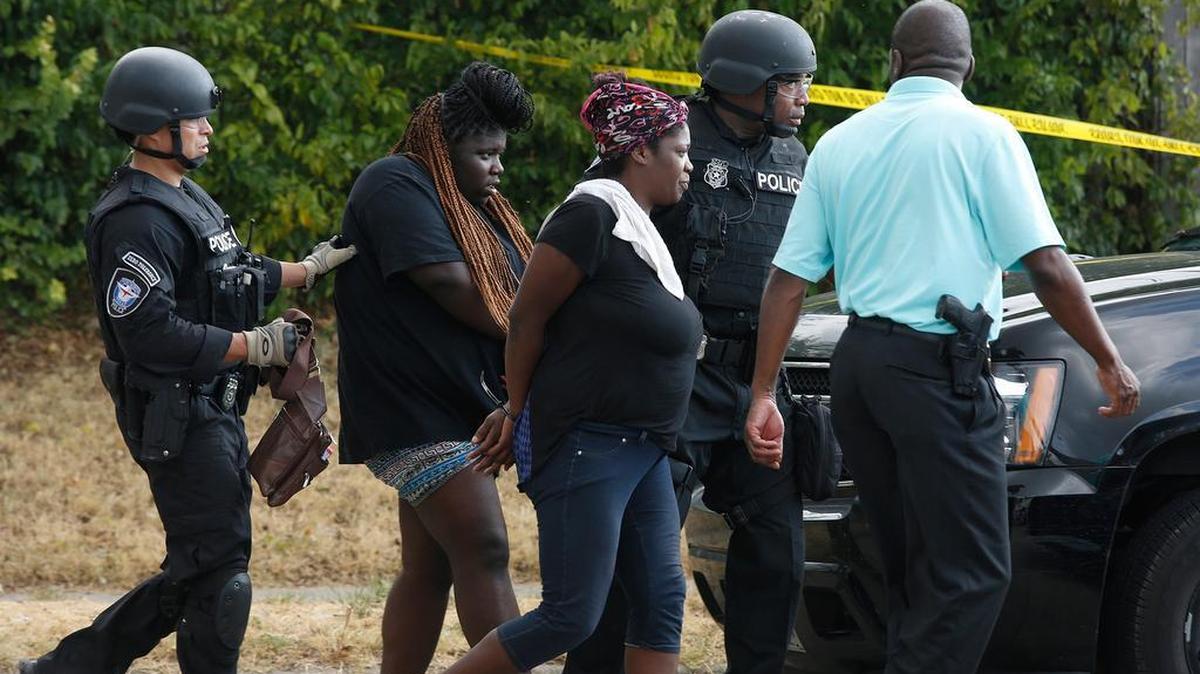 
Two women are led out of a house during a standoff in the 5300 block of Whitten Street Monday, Aug. 24, 2015. 
