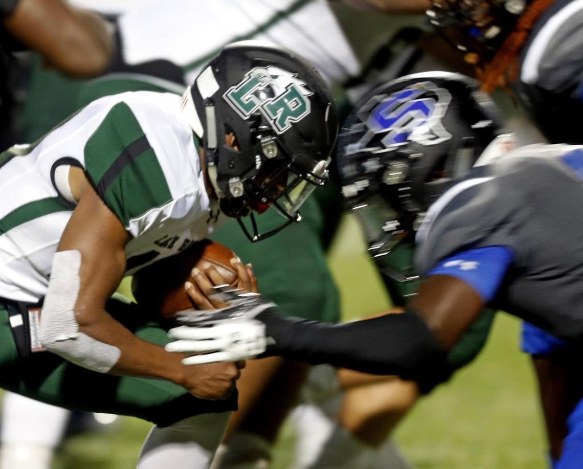 Lake Ridge running back Cartraven Walker collides with a Mansfield Summit defender during a September game at Newsom Stadium.