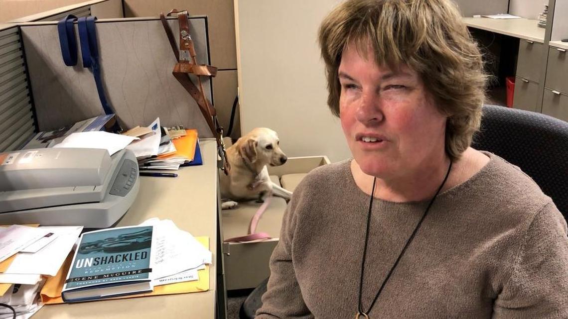 Fort Worth Star-Telegram reporter Liz Campbell works at her desk while Barbara, her service dog, waits for her next task.