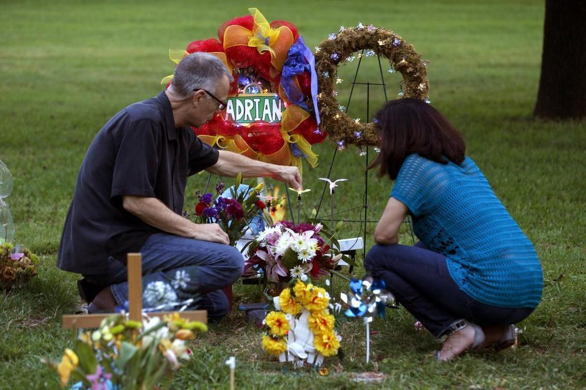 John Winkler and Laura Martinez tend to the gravesite of Adrian Langlais. Winkler and Martinez frequently cared for Adrian and considered themselves adoptive grandparents to the boy.