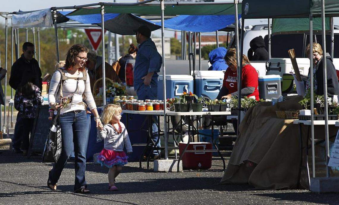Shopper Kathleen Cluchey, her daughters Naomi, 3, and Clara Bell, 1, browse the merchandise at the Cowtown Farmers Market in Fort Worth in 2015.