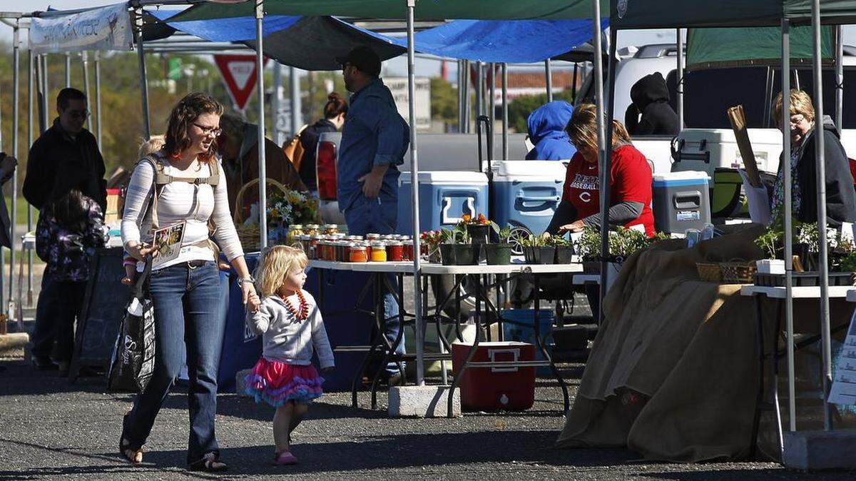 Shopper Kathleen Cluchey, her daughters Naomi, 3, and Clara Bell, 1, browse the merchandise at the Cowtown Farmers Market in Fort Worth in 2015.