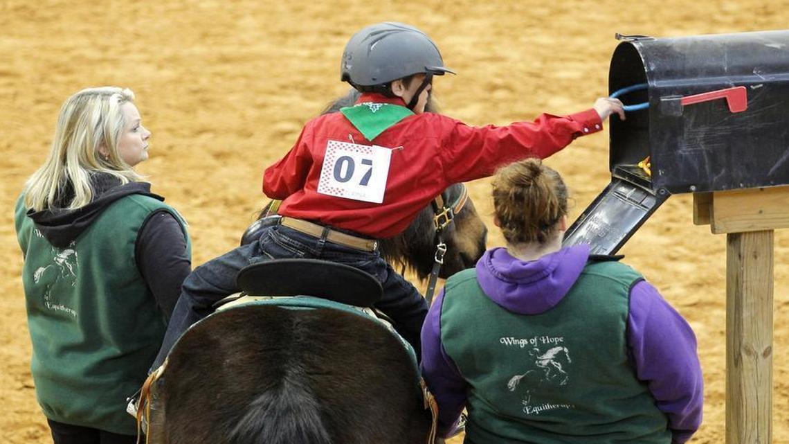 Colby Tutt retrieves a ring from a mailbox as one of the tasks he and his horse perform at the Chisholm Challenge riding event for special needs riders at Will Rogers Memorial Center in January 2013.