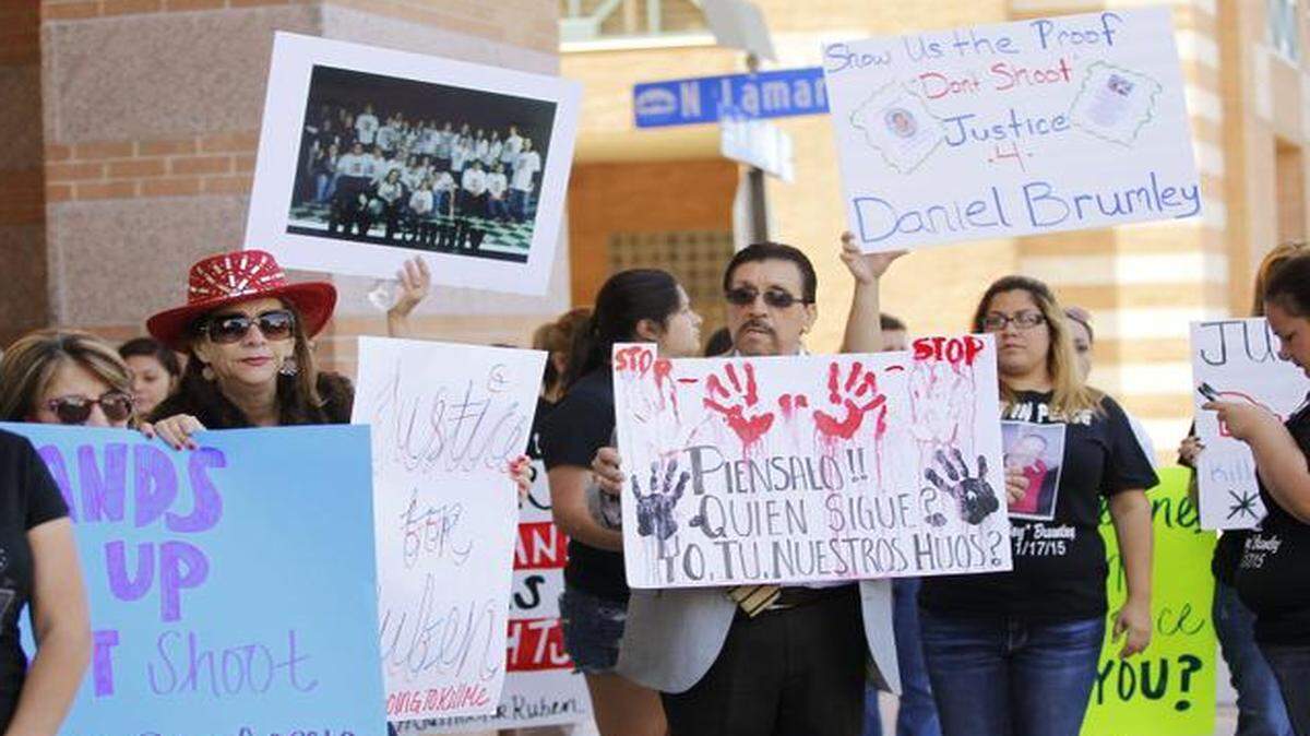 
Protestors hold signs appealing for action in the deaths of Rubén García Villalpando and Daniel Brumley, both shot by police officers this year.
