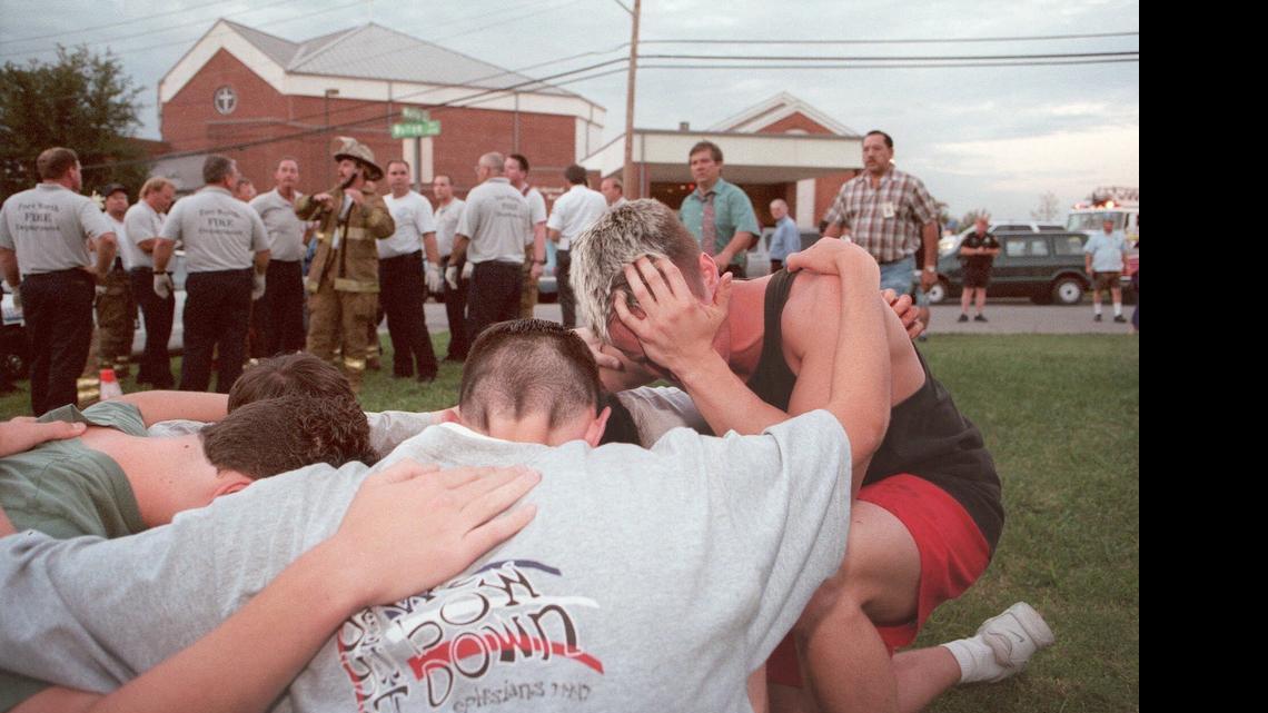 
A group of young men pray outside Wedgwood Baptist Church in Fort Worth on Sept. 15, 1999, after a gunman open fire inside the church. Seven people died and seven others were injured after a man dressed in black walked into a church service filled with teenagers, pulled a gun and began shooting, police said. 

