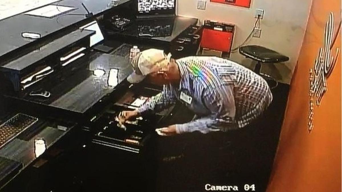 Surveillance cameras showed the “firefighter” removing money from the motel’s cash register.