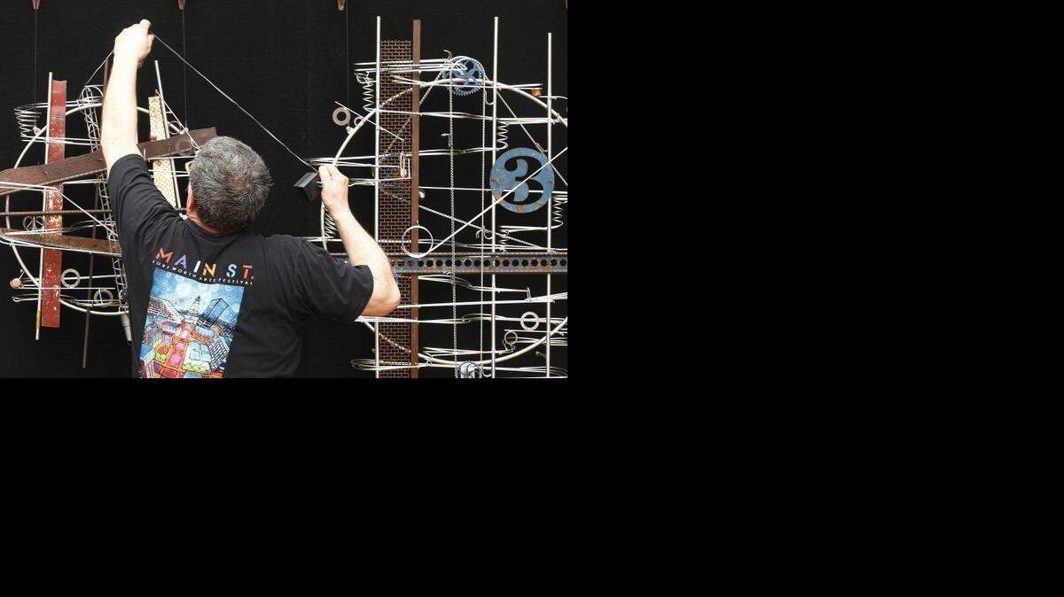 
Minnesota artist Jeffrey Zachman places his kinetic sculptures on the outside of his tent Wednesday while setting up for the opening of the Main St. Fort Worth Arts Festival. 
