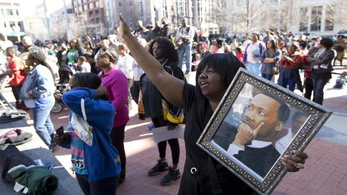 
Sylvia Robinson holds a portrait of Martin Luther King Jr. painted by her son in Sundance Square after the parade. The Fort Worth Martin Luther King Jr. Day Parade was followed by the MLK Rally, which featured step groups, dancers, high school bands and skits in Sundance Square Monday. 
