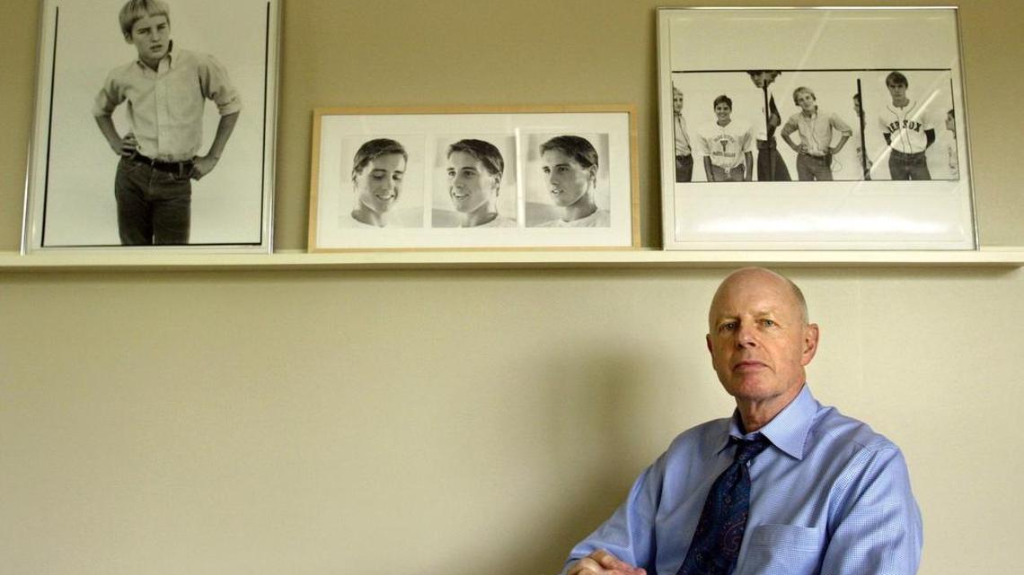 In this Friday, April 30, 2004, photo, Robert A. “Bob” Wilson, the father of actors Owen, Luke and Andrew Wilson, poses for a photo at his office, in Dallas. Robert A. Wilson, also a public television station executive who introduced “Monty Python’s Flying Circus” to its first American audience, died Friday, May 5, 2017, in Dallas. He was 76. On the wall are photographs of his sons when they were young. At left is a portrait of Owen taken by photographer Richard Avedon, while at center are portraits of Luke taken by their mother, Laura Wilson. At right are portraits of the three sons: Luke, Owen and Andrew, taken by Avedon.