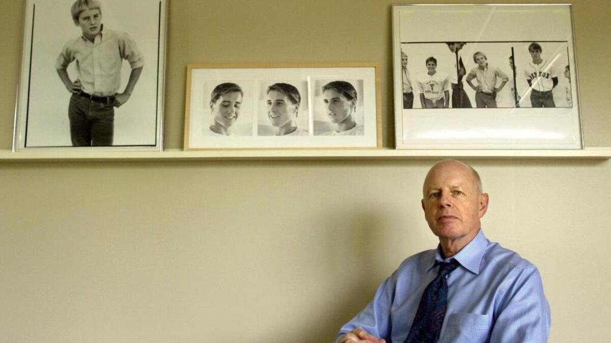 In this Friday, April 30, 2004, photo, Robert A. “Bob” Wilson, the father of actors Owen, Luke and Andrew Wilson, poses for a photo at his office, in Dallas. Robert A. Wilson, also a public television station executive who introduced “Monty Python’s Flying Circus” to its first American audience, died Friday, May 5, 2017, in Dallas. He was 76. On the wall are photographs of his sons when they were young. At left is a portrait of Owen taken by photographer Richard Avedon, while at center are portraits of Luke taken by their mother, Laura Wilson. At right are portraits of the three sons: Luke, Owen and Andrew, taken by Avedon.