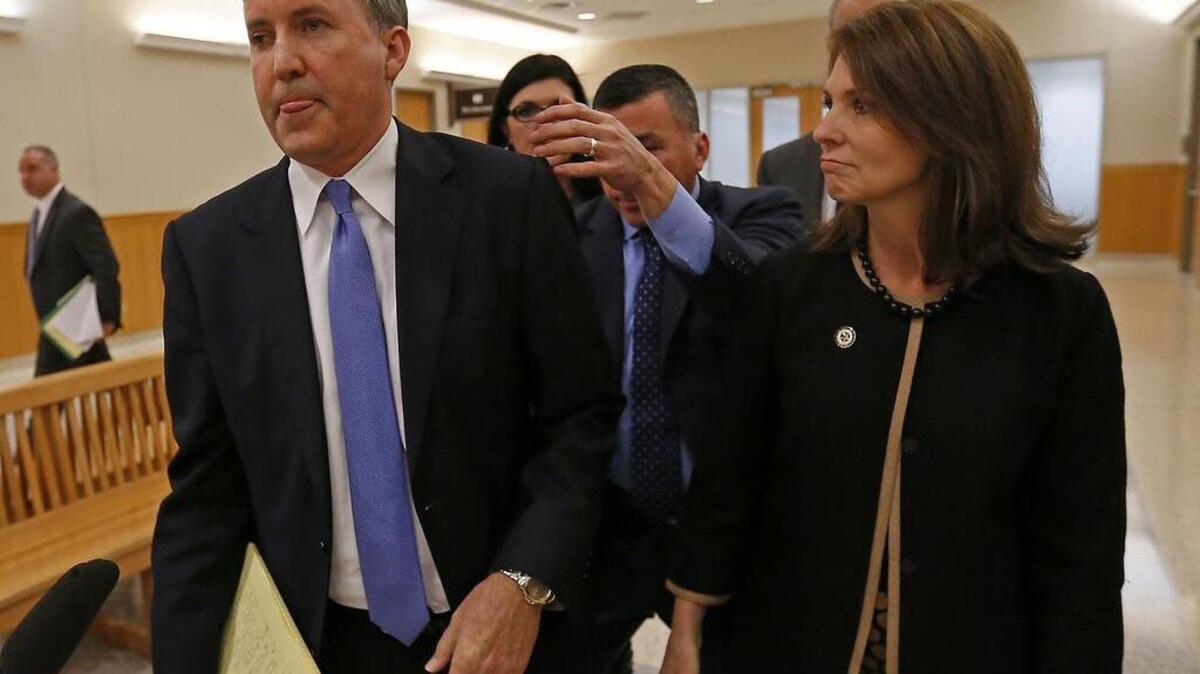 Texas Attorney General Ken Paxton, left, and his wife Angela leave a courtroom after his pre-trial motion hearing at the Collin County courthouse in December 2015.