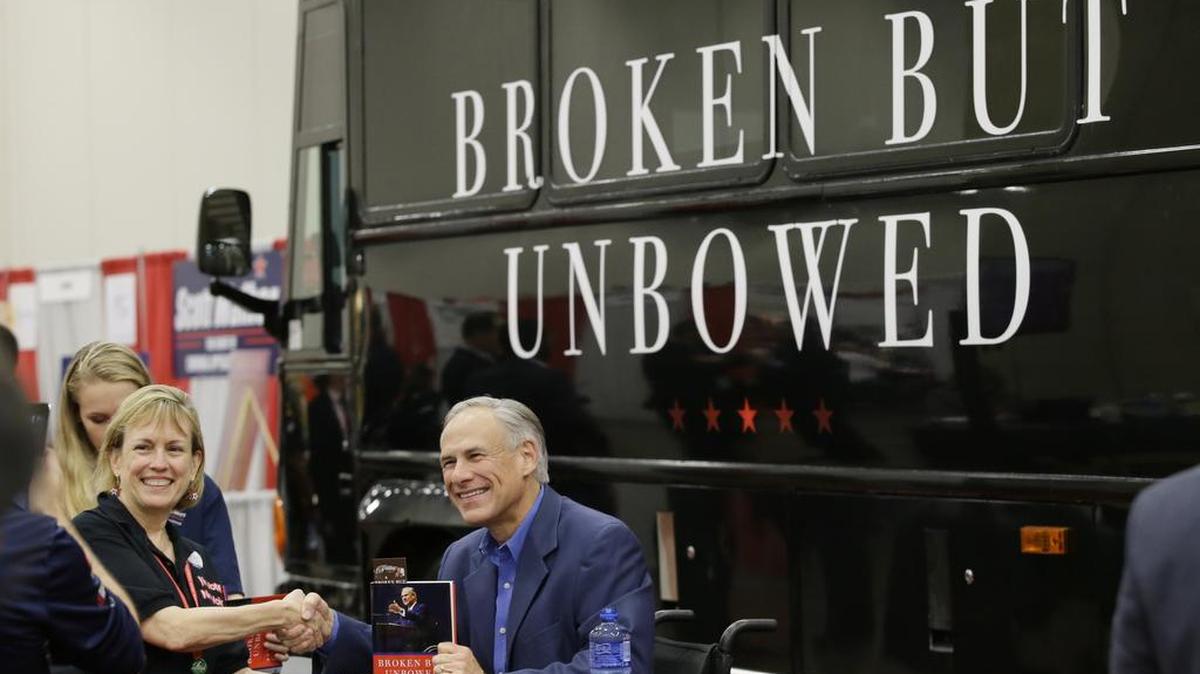 Gov. Greg Abbott signed books in front of his tour bus at the Dallas state GOP convention.