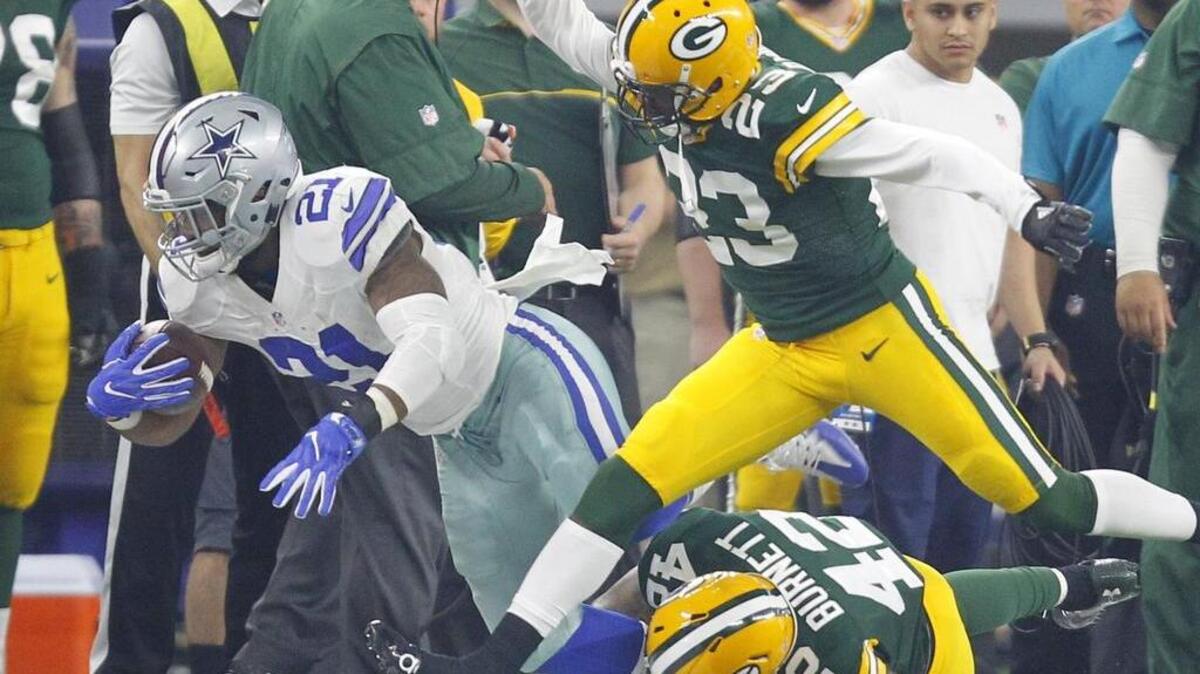 Green Bay Packers cornerback Damarious Randall and strong safety Morgan Burnett try to bring down Dallas Cowboys running back Ezekiel Elliott.