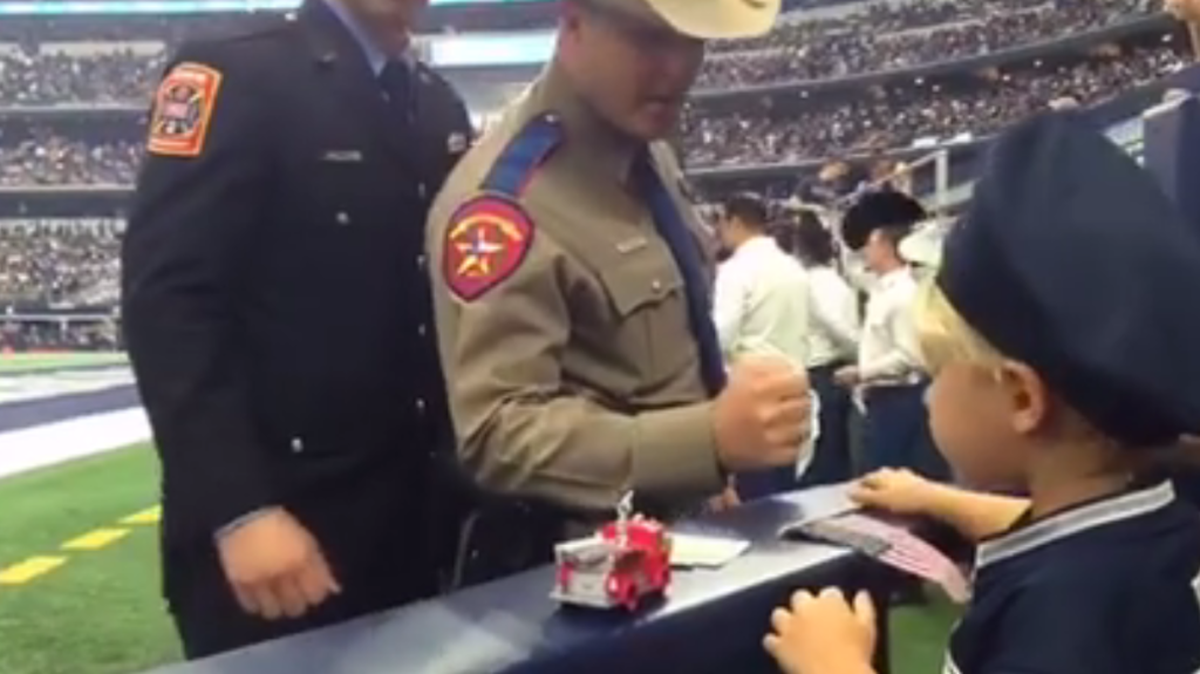 A state trooper, now identified as Dave Stewart, gives his hat to a 2-year-old fan Sunday following a a 9/11 tribute to first responders.