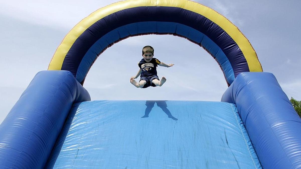Mason Stanger, 5, catches some air on an inflatable slide during Keller Fest at Keller Town Hall Saturday afternoon April 12, 2014.