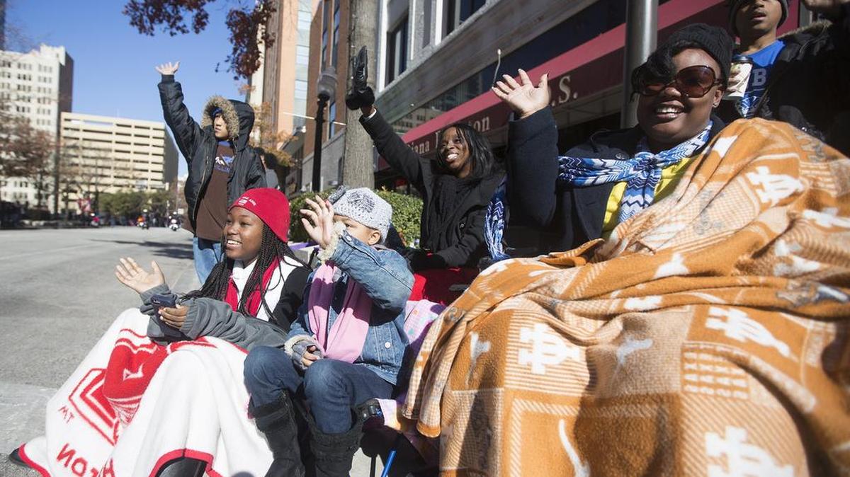 The Klein and Ivory families wave as the parade passes during the Martin Luther King Jr. Day March, Parade and Rally on Jan. 18, 2015, in Downtown Fort Worth.