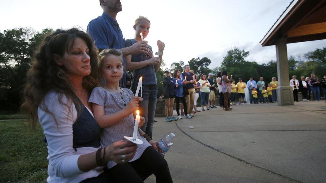 Summer, Trinity, 5, John and Faith Conn participate in a candlelight vigil for Leiliana Wright at Katherine Rose Memorial Park in Mansfield.