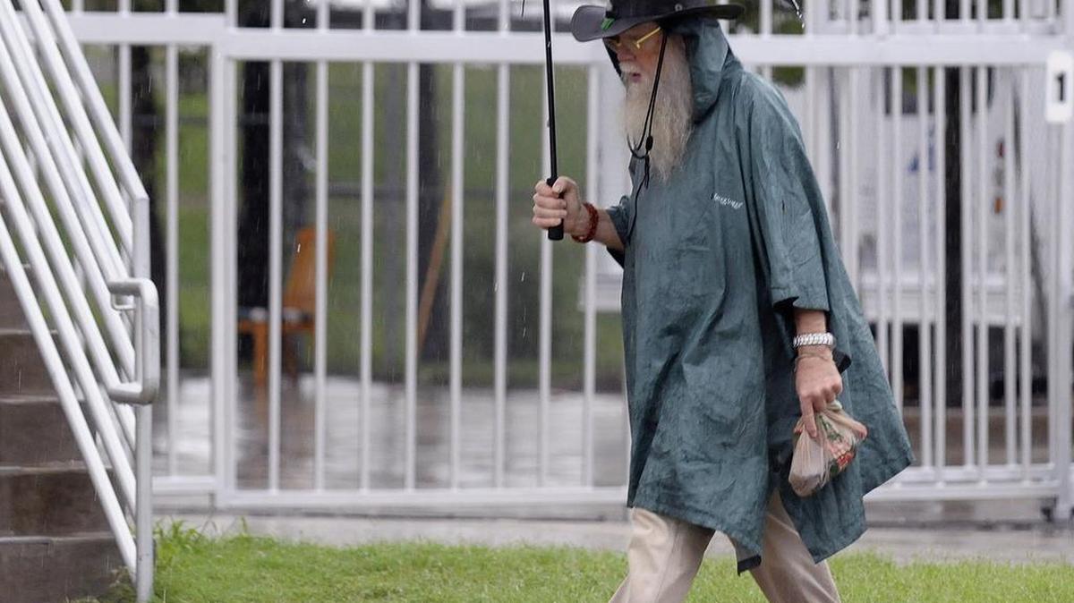 A pedestrian uses an umbrella to shield the rain. Precipitation for June is nearly 5 inches above average.