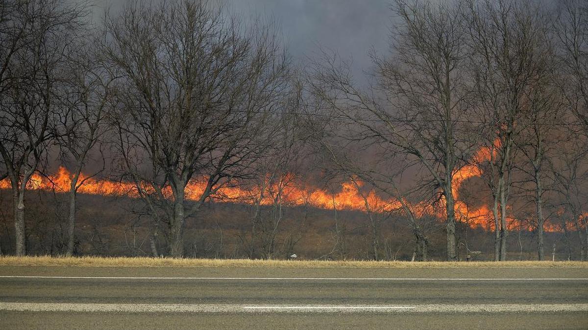 Grass and weeds burn just north of I-20 in Parker County, Monday afternoon. All lanes of Interstate 20 and Interstate 30 from Loop 820 to Farm Road 5 in western Tarrant and eastern Parker counties were closed temporarily due to heavy smoke.
