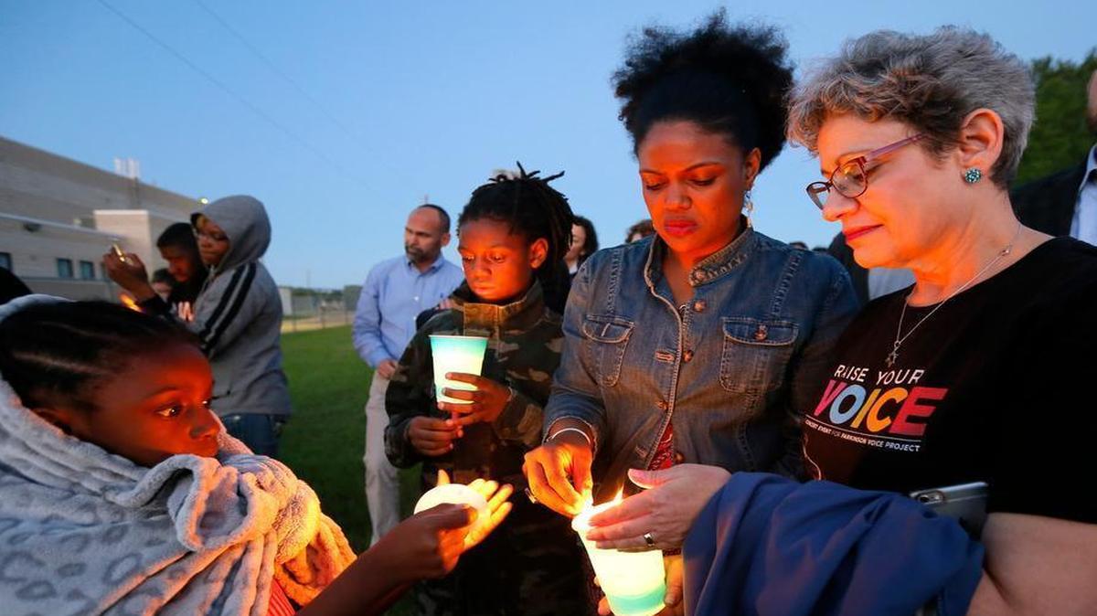 Hope Waters, left, her brother Jeremiah, center rear, and their mother Yulise, center right, light candles with Linda Abrasion Evans, right, during a candle light vigil for Jordan Edwards in Balch Springs, Texas, Thursday, May 4, 2017. The prosecutor's office investigating the death of a black teenager who was shot by a Dallas-area police officer had once filed a complaint over that officer's aggressive behavior, according to records obtained Thursday by The Associated Press.