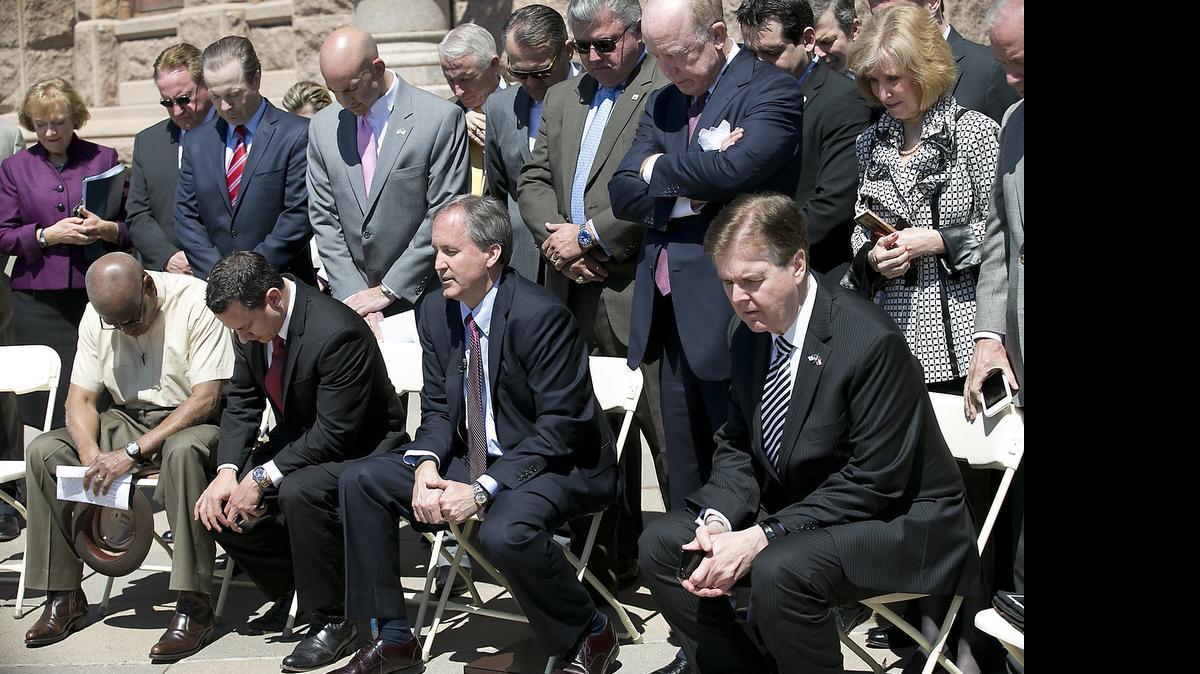 
Texas Lt. Gov. Dan Patrick, right, joins Attorney General Ken Paxton and other lawmakers and religious leaders in prayer during a Defense of the Texas Marriage Amendment Rally outside of the state Capitol, Monday, March 23, 2015, in Austin. Hundreds of people gathered Monday afternoon at the Texas Capitol to rally in support of what they call “Biblical marriage”, a union between a man and a woman, at an event headlined by Alabama Supreme Court Chief Justice Roy Moore. (AP Photo/Austin American-Statesman, Ralph Barrera) AUSTIN CHRONICLE OUT, COMMUNITY IMPACT OUT, INTERNET AND TV MUST CREDIT PHOTOGRAPHER AND STATESMAN.COM, MAGS OUT
