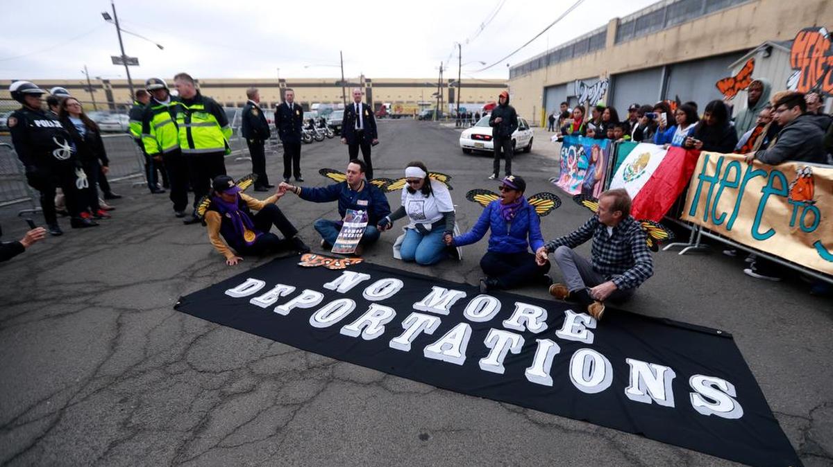 Activists block a street as police officers look on during an immigration protest outside of a detention center Thursday in Elizabeth, N.J. The activists were taken into custody.