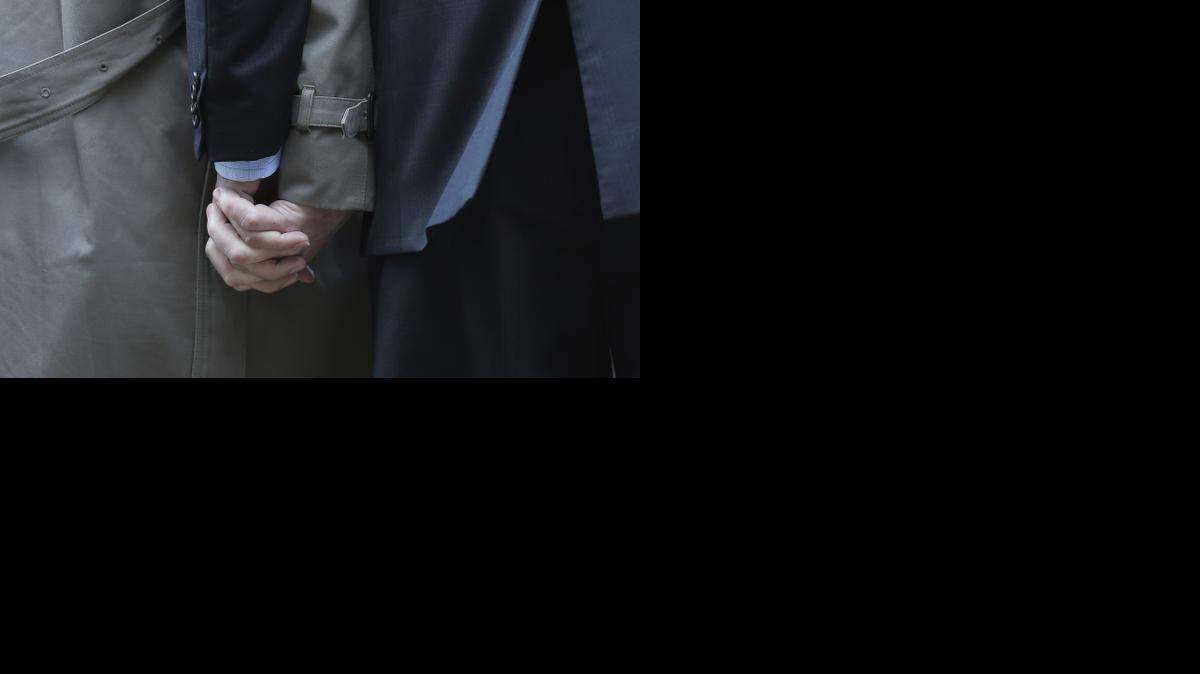 
Mark Phariss, left, clutches the hand of partner Victor Holmes, right, as they talk to the media at the U.S. Federal Courthouse on Wednesday, Feb. 12, 2014, in San Antonio. District Judge Orlando Garcia said Wednesday he would issue a decision later after two Texas men filed a civil rights lawsuit seeking permission to marry, and a lesbian couple sued to have their marriage recognized. (AP Photo/Eric Gay)
