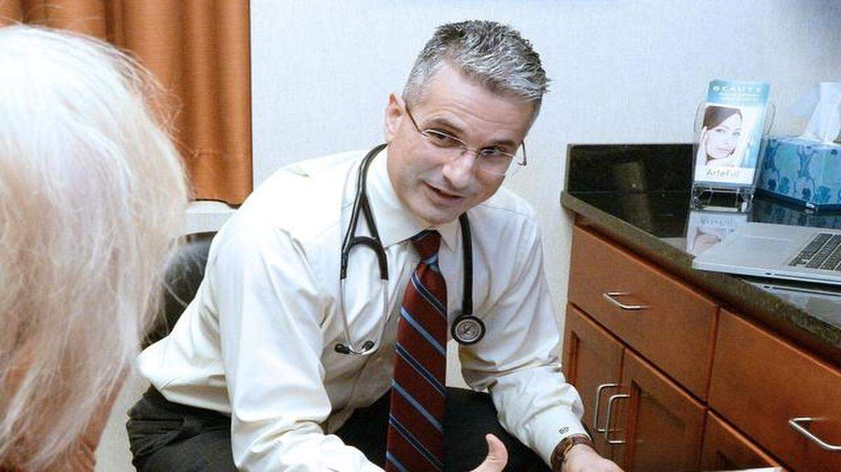 Dr. Dino Kanelos of Carolina Family Healthcare talks with a Medicare patient, 75,   about preventive health in Charlotte, N.C.