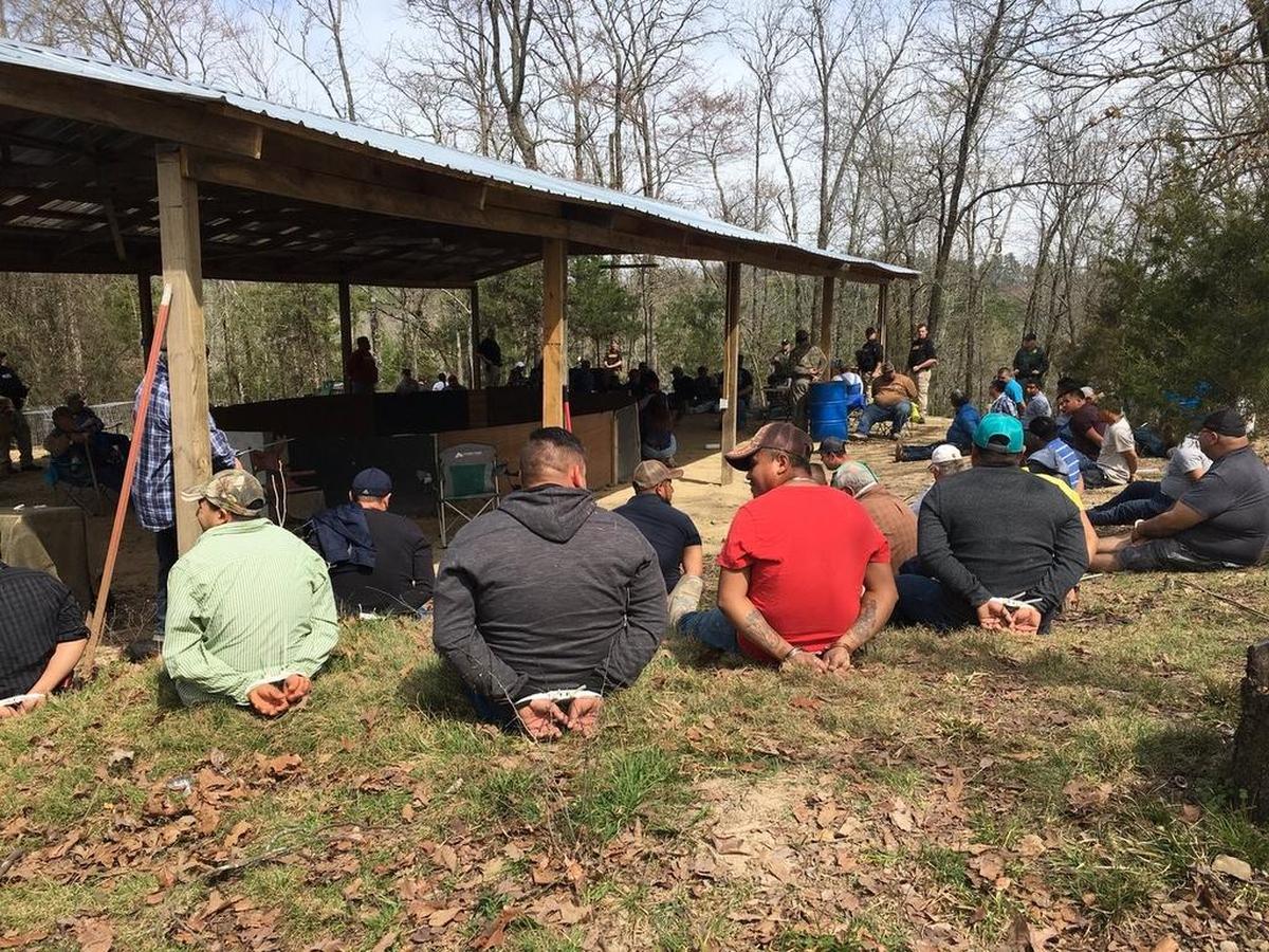 Suspects in the March 17 cockfighting raid in Sevier County (Ark.) sit in handcuffs surrounding an alleged cockfighting pit.