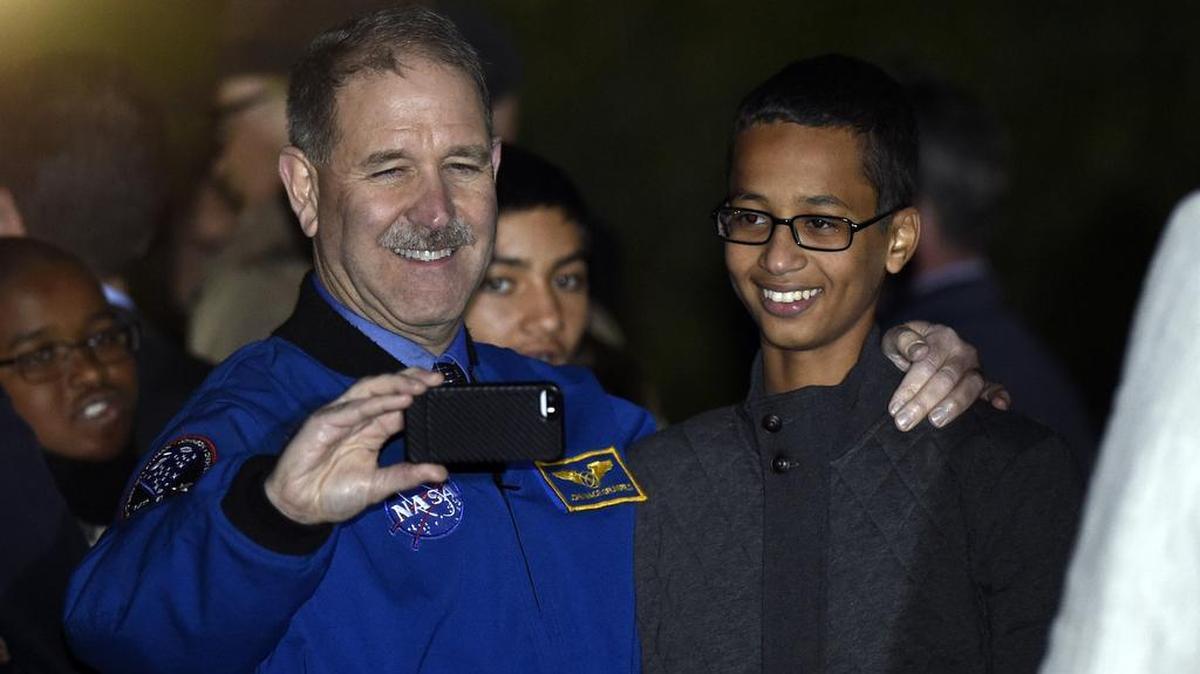 Live: John M. Grunsfeld, left, NASA's Associate Administrator for the Science Mission Directorate, takes a photo with Ahmed Mohamed, right, the Texas teenager arrested after a homemade clock he brought to school was mistaken for a bomb during the second-ever White House Astronomy Night on the South Lawn of the White House in Washington, Monday, Oct. 19, 2015. (AP Photo/Susan Walsh)