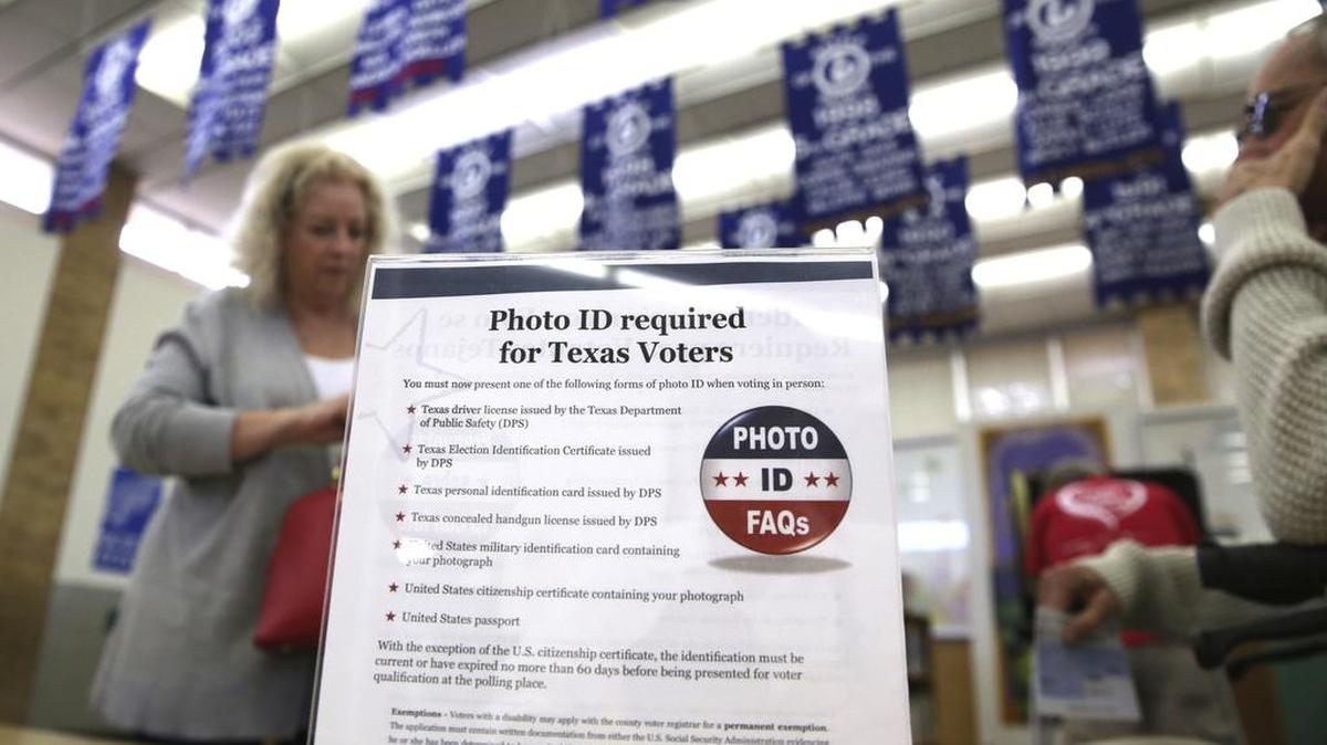 In this March 1, 2016, file photo, a sign tells voters of voter ID requirements before participating in the primary.